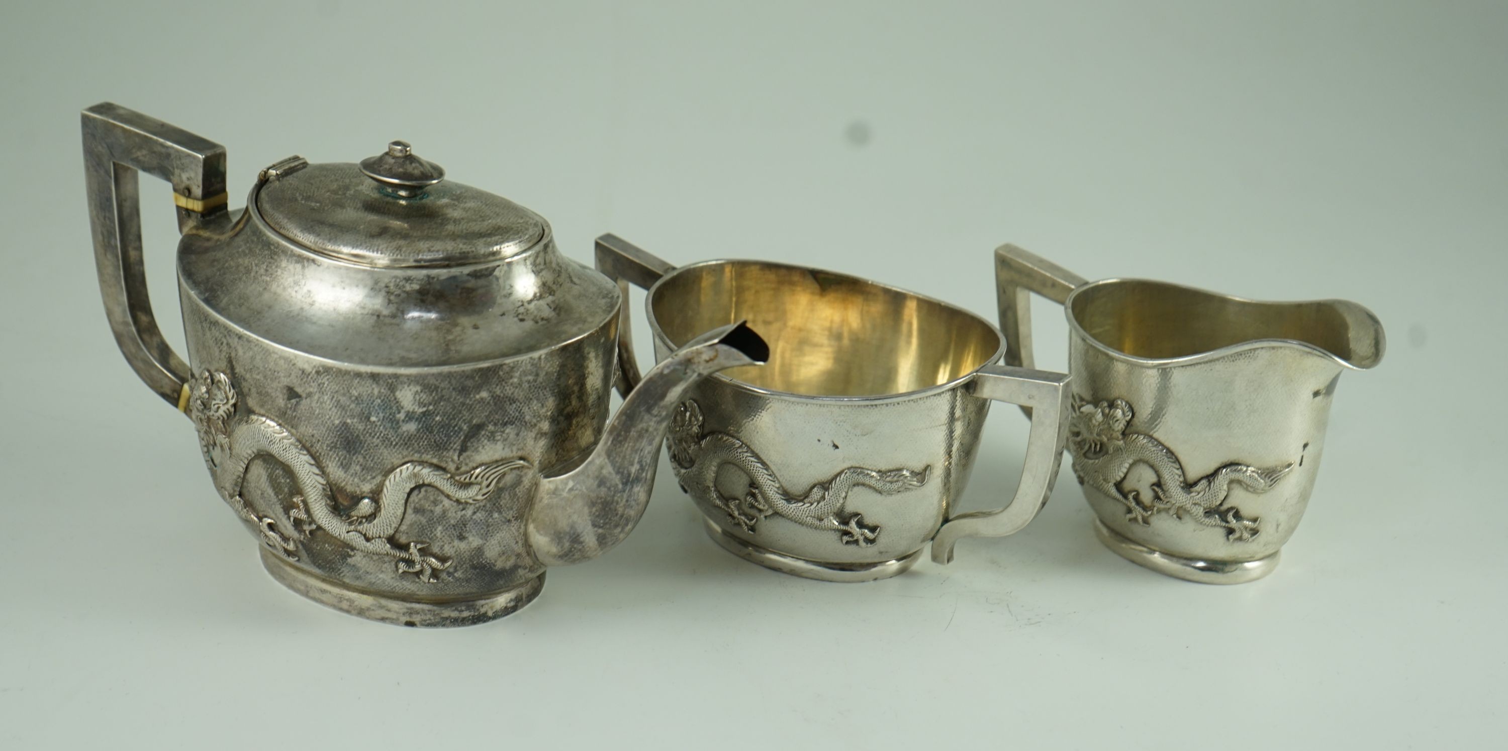 An early 20th century Chinese Export three piece silver tea set and matching silver inlaid hardwood two handled tea tray, by Luen Hing?